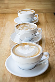 Three cups of hot cappuccino coffees photo