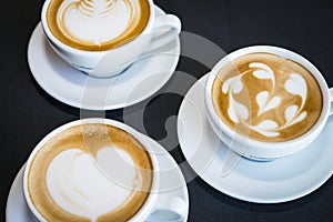 Three cups of hot cappuccino coffees photo