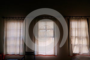 three curtained windows in an old hotel in Morocco