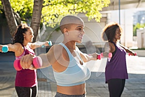 Three curvy women exercising with dumbbells