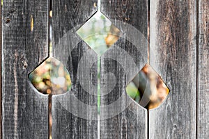 Three cut flower-shaped holes on wooden door of the old barn