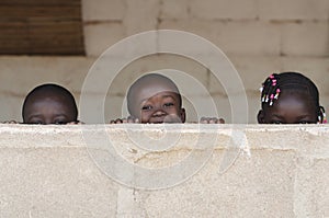 Three Cute African Children Playing Peekaboo Outdoors