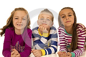 Three cute kids laying down with fun expression