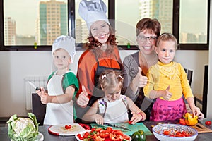 Three cute kids are preparing a salad in the kitchen