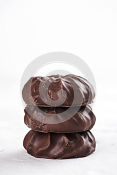 Three dark chocolate-coated zefir top view isolated on white background
