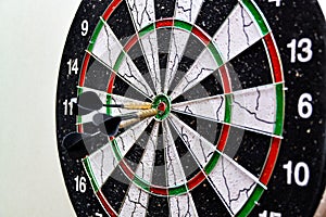 Three darts hit the center of the board while playing darts