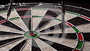 Three darts hit the dartboard. Lucky - one of the darts hits the bull's eye. The concept of winning and luck. Close