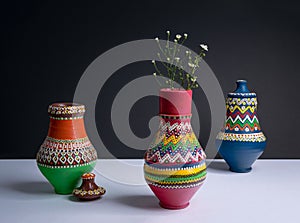 Three decorated pottery vases with small flowers with harsh shad