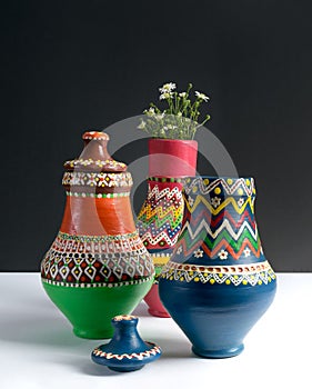 Three decorated pottery vases with small flowers