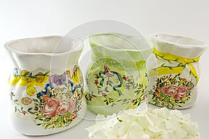 Three decoupage decorated flower pattern jar on white background