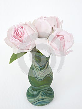 Three delicate pink roses in a malachite green vase