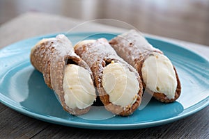 Three delicious typical Sicilian cannoli filled with ricotta chse cream photo