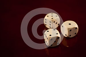 Three dice cubes on dark reflecting wooden background games fortune