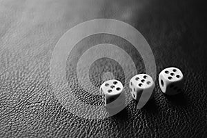 Three dice with fives on a black leather table in corner. Bw photo