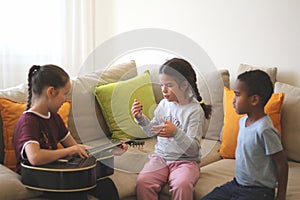 three different color kids are playing together in a room