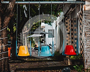 three different color swings in the park