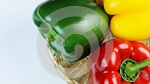 Three different colored bell peppers isolated against the white background. Red, yellow and green capsicums also known