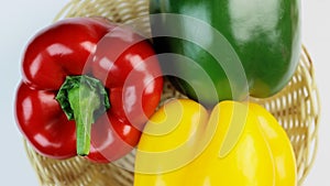 Three different colored bell peppers isolated against the white background. Red, yellow and green capsicums also known