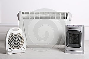 Three different electric heaters on floor in room photo