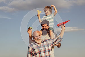 Three different generations ages: grandfather father and child son together. Happy family. Grandfather playtime. Happy