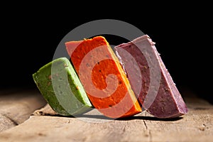 Three different gourmet cheeses on rough woode planks