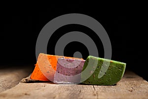 Three different gourmet cheeses on rough woode planks