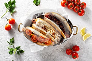 Three different hot dog grills served in a pan on light background, top view