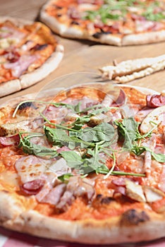 Three different pizzas on wooden table. Freshly baked traditional Italian Pizza over wooden background