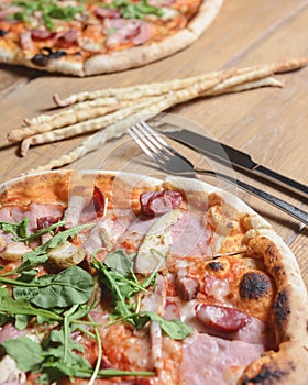 Three different pizzas on wooden table. Freshly baked traditional Italian Pizza over wooden background