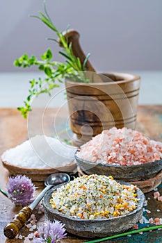 Three different types of natural salt in stone bowls on wooden s