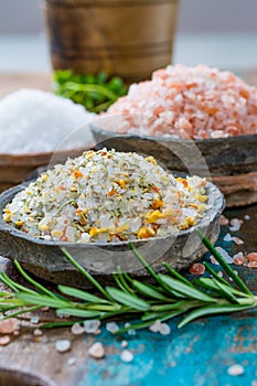 Three different types of natural salt in stone bowls on wooden s photo