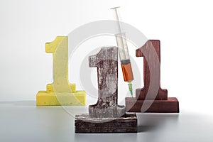 Three digits one made of wood and syringe