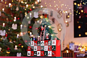 Three-dimensional Advent Calendar in Front of Christmas Tree in Christmassy illuminated Room