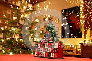 Three-dimensional Advent Calendar with stylised Christmas Tree in the middle of Christmassy illuminated Family Room
