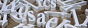 Three-dimensional letters of white letters intended for making advertisements are scattered on the floor