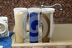 Three dirty used osmosis water filter cartridges