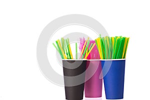 Three disposable cups with multi colored plastic straws. Ban single use plastic
