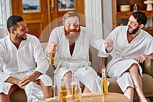 Three diverse cheerful men in bathrobes