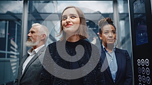 Three Diverse Multiethnic International People Ride a Glass Elevator to Office in a Modern Busines