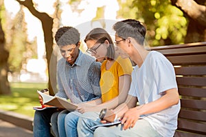 Three Diverse Students Learning Sitting Outdoors In University Campus