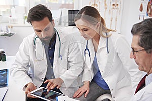 Three doctor working with tablet in doctorâ€™s office