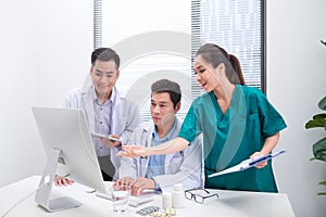 Three doctors discussing patient files on office
