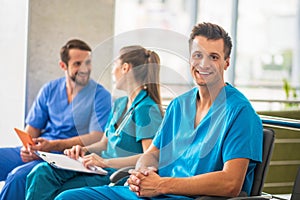 Three doctors sitting together and talking during changeover