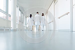 Three doctors walking down a corridor in hospital