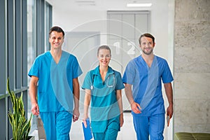 Three doctors walking together in the hospital corridor