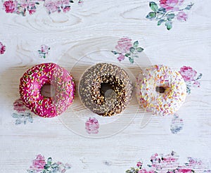 Three donuts on a background in the style of a shabby chic.