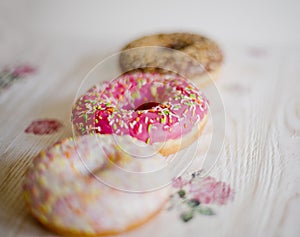 Three donuts on a background in the style of a shabby chic.