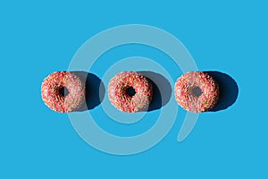 Three donuts in a row on a blue background