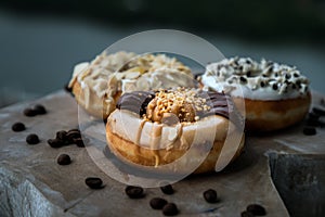 Three doughnuts covered with Choco peanut butter, Cookies and creme and Almendras photo