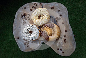 Three doughnuts covered with Cookies and creme, Almendras and Choco peanut butter photo